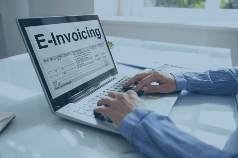 Person erstellt eine elektronische Rechnung (E-Invoicing) am Laptop mit PACS Software